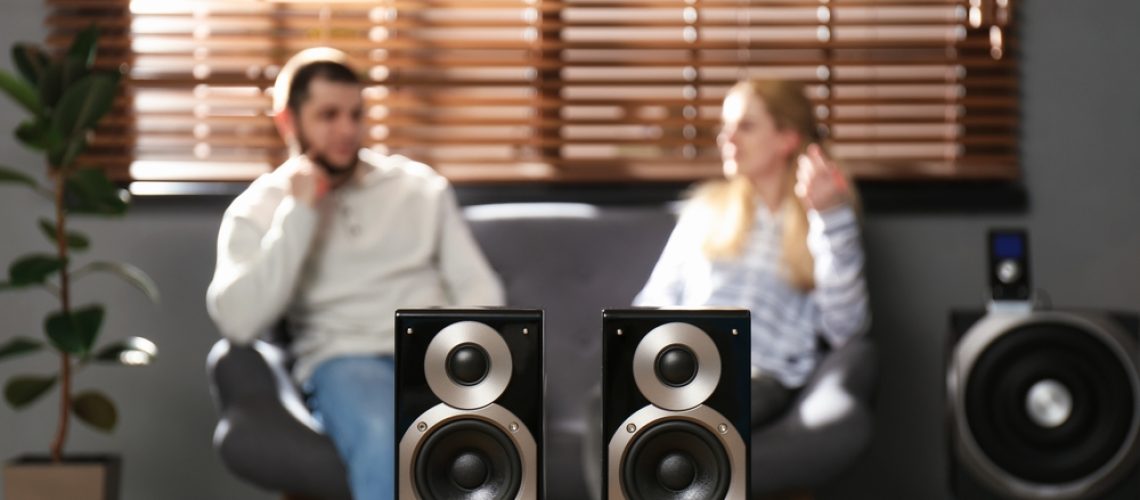 People enjoying music with modern audio speaker system in living room